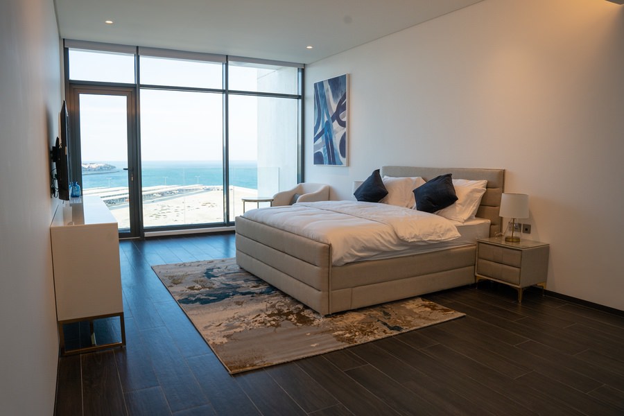 High-end master bedroom with a scenic view and custom interior design by Almoayyed Contracting Group.