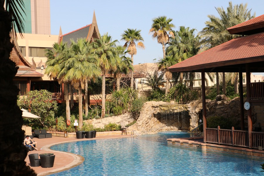 Outdoor swimming pool at a luxury resort with traditional architectural elements by Almoayyed Contracting Group.
