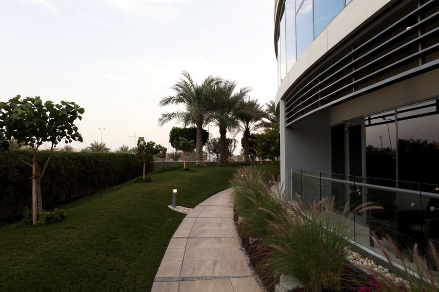 Landscaped walkway and exterior architectural finishes by Almoayyed Contracting Group.