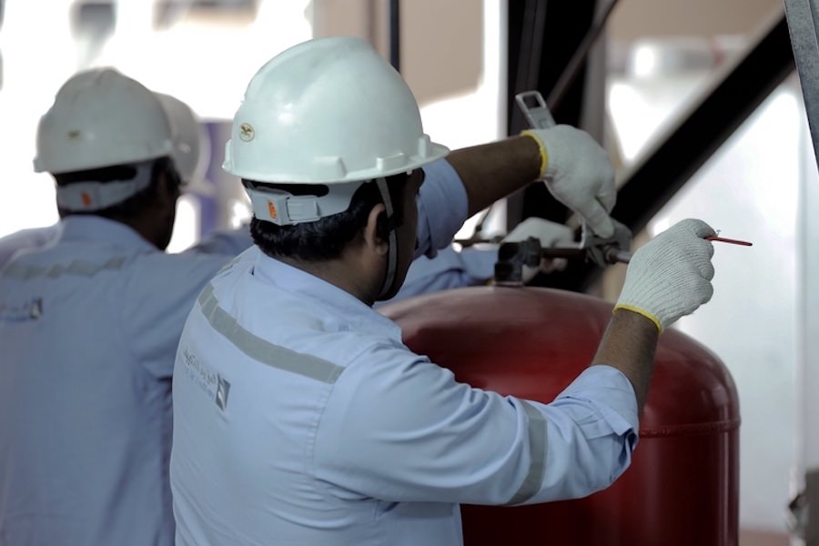 Almoayyed Contracting Group technician performing maintenance on industrial mechanical systems.