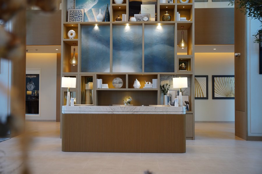 Bespoke reception desk and luxury wood paneling for a corporate office by Almoayyed Contracting Group.