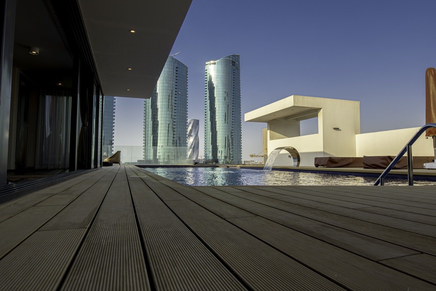 Modern architectural project by Almoayyed Contracting Group featuring luxury building design and an outdoor pool.