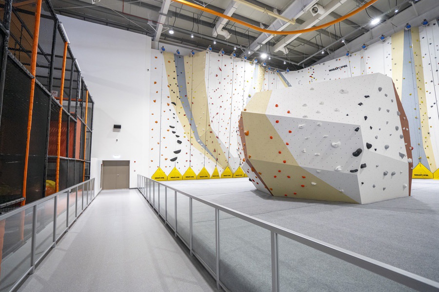 High-ceiling indoor facility with professional wall finishes and glass railings by Almoayyed Contracting Group.