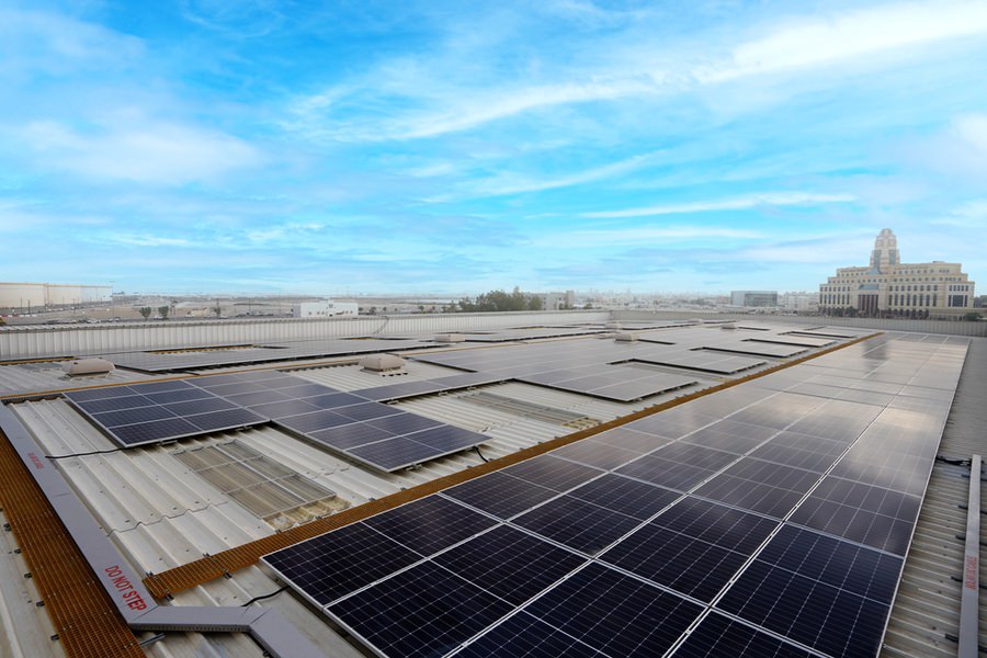 Extensive photovoltaic solar array on a commercial roof completed by Almoayyed Contracting Group.