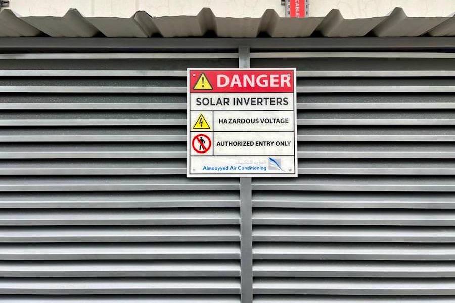 Safety signage installed on a secure industrial enclosure by Almoayyed Contracting Group.