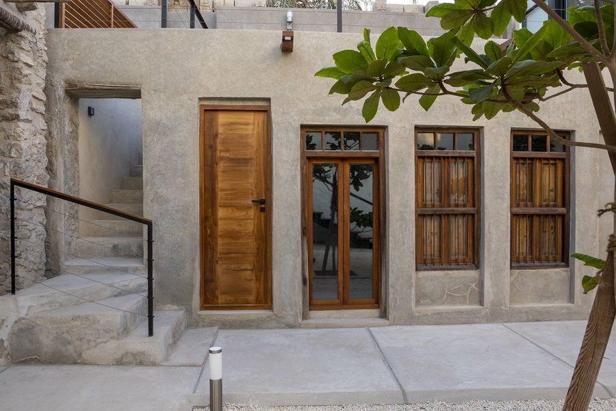 Traditional architectural wooden door and stone facade work by Almoayyed Contracting Group.