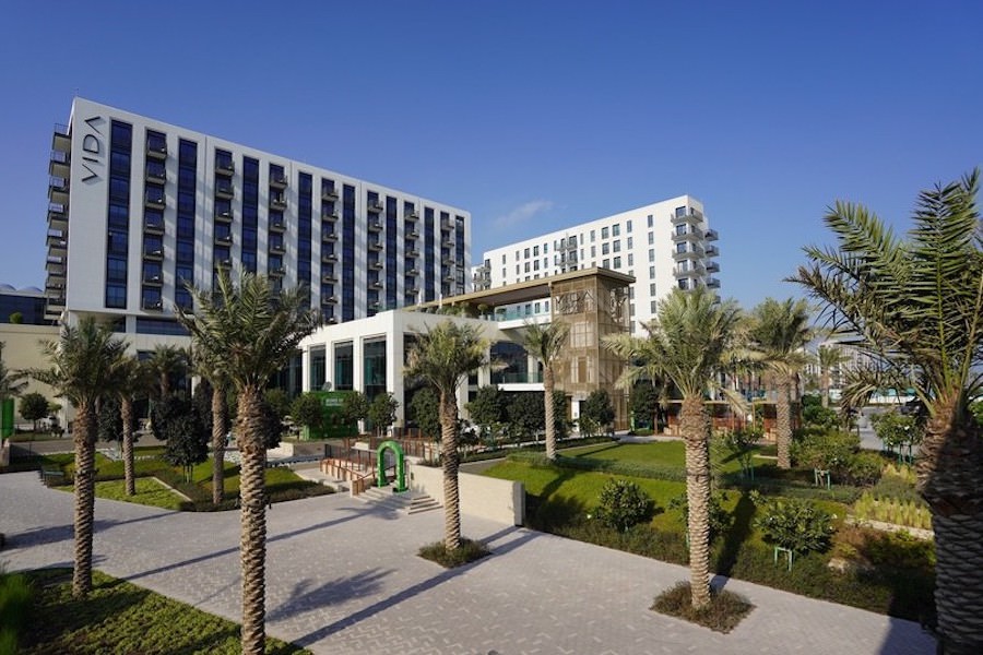 Modern apartment building with professionally landscaped courtyard and palm trees by Almoayyed Contracting Group.