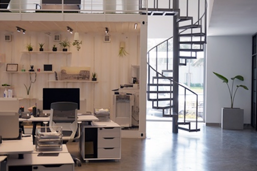 Modern office interior featuring a spiral staircase and workstations by Almoayyed Contracting Group.