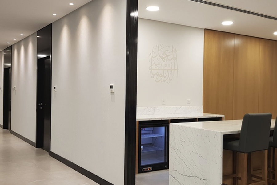 Sleek minimalist office corridor with integrated lighting by Almoayyed Contracting Group.