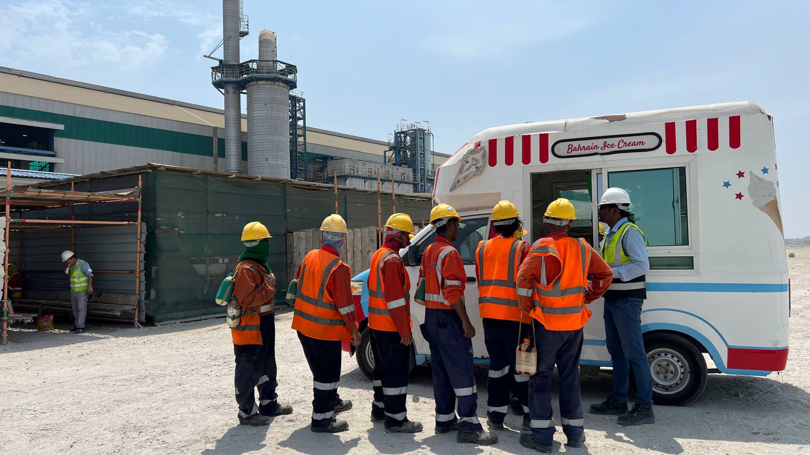 Almoayyed Contracting Group on-site workers wearing safety helmets and high-visibility vests.